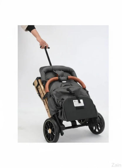 Gray stroller with brown handlebar being pushed on a white background