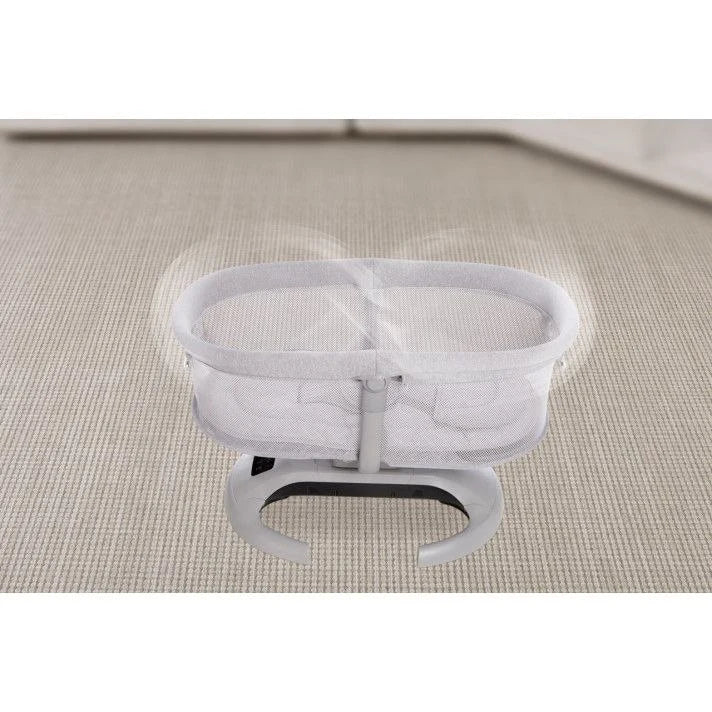 White bassinet on a textured surfaceسرير ماستيلا الهزازيعمل بابلكيشن علي الموبايل و سرعات هز مختلفه و تايمر